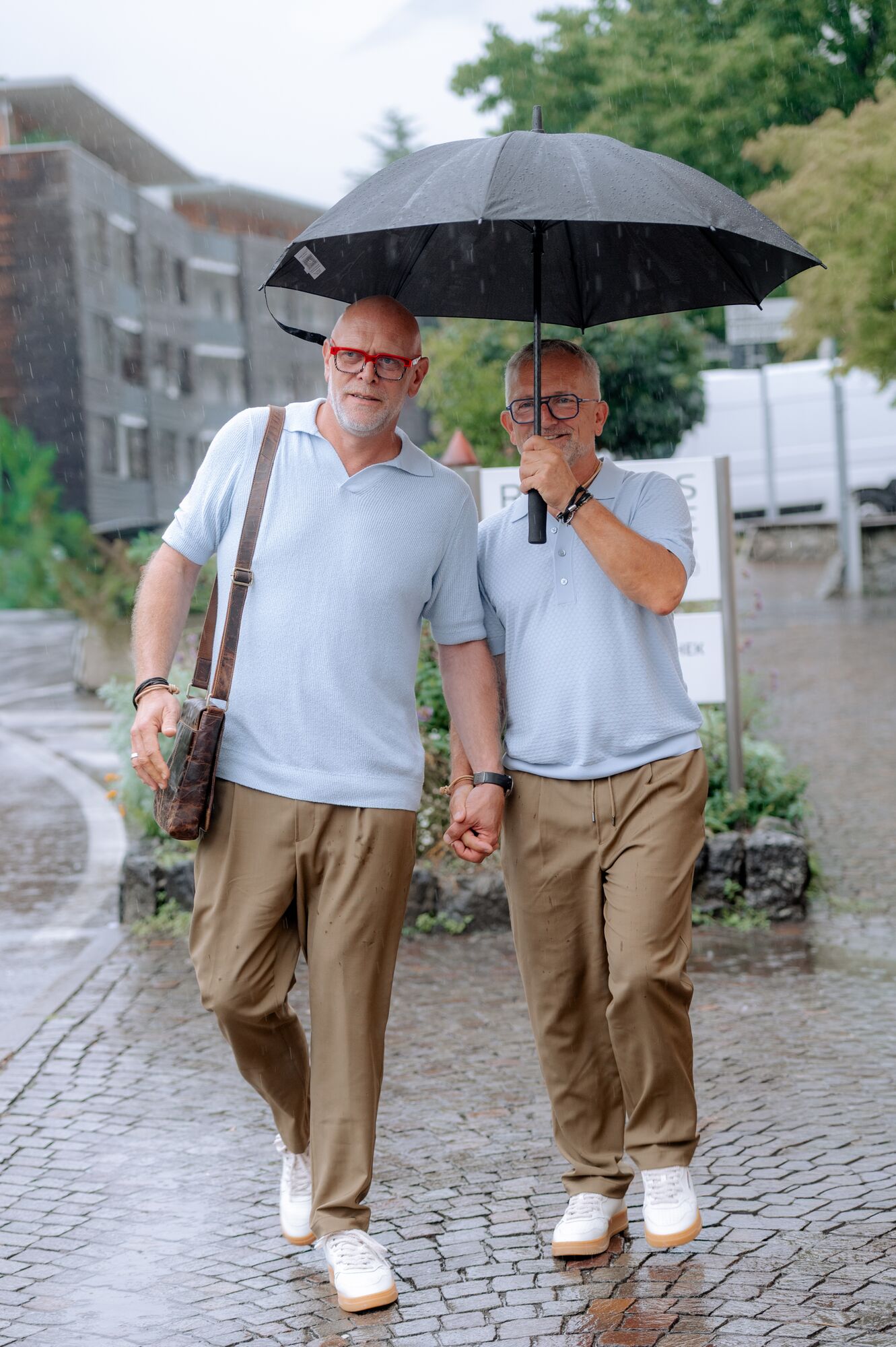 Thorsten Rausch und Ingmar Laimer verlassen das Rathaus in Algund Hand in Hand unter einem Regenschirm
